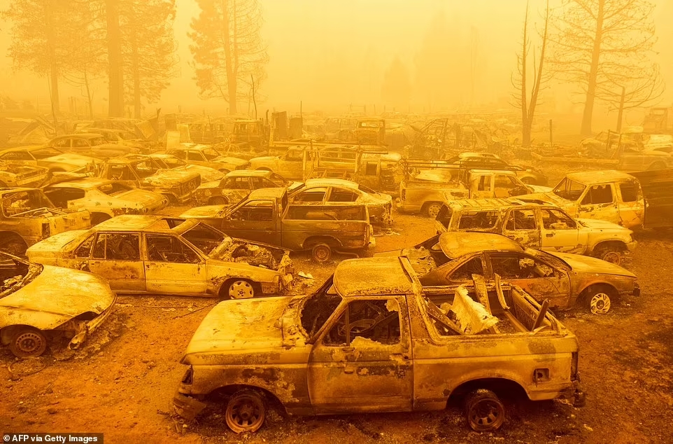 46409807 9959185 dozens of burned vehicles rest in heavy smoke during the dixie f a 249 1630892082601