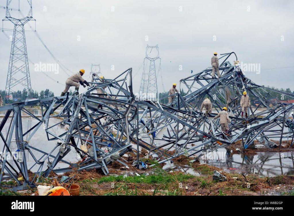Chinese technicians try to clear away a collapsed pylon devastated by the massive tornado in funing county yancheng city east chinas jiangsu provin W8B2GP